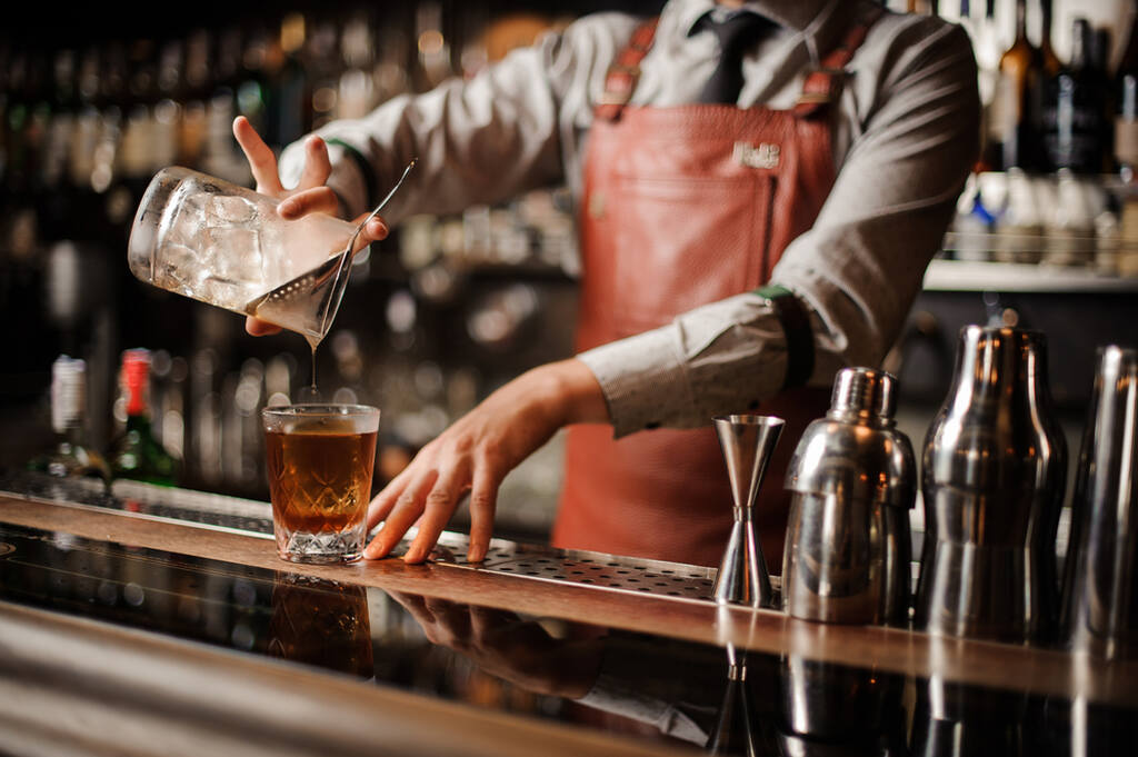 Mixologia, bartender finalizando drink com cachaça artesanal