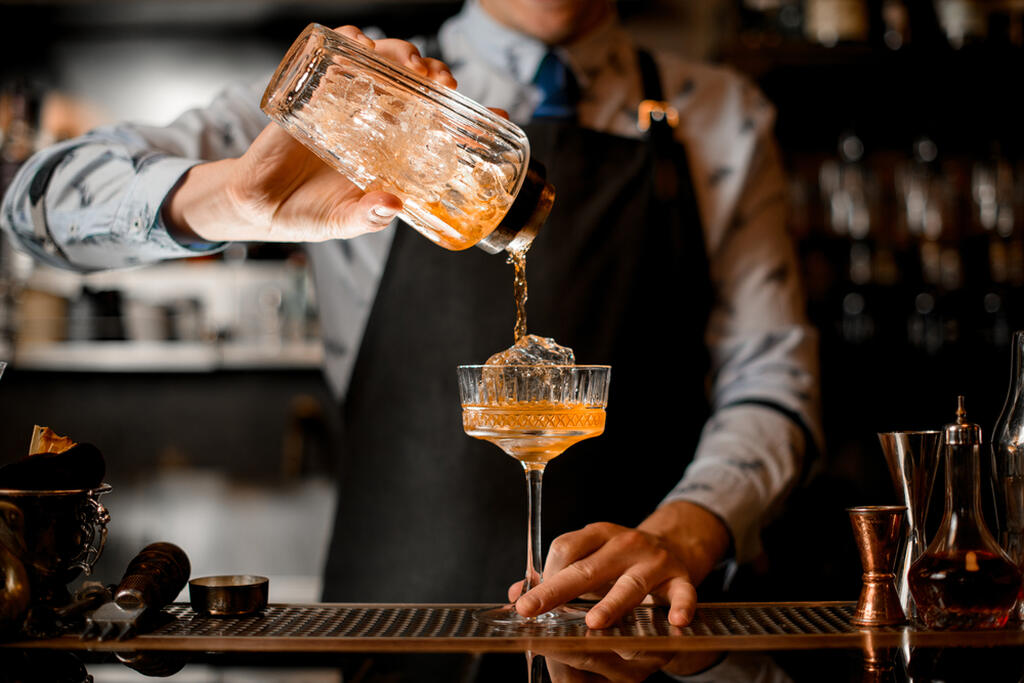 Bartender finalizando drinks a partir de técnicas de mixologia